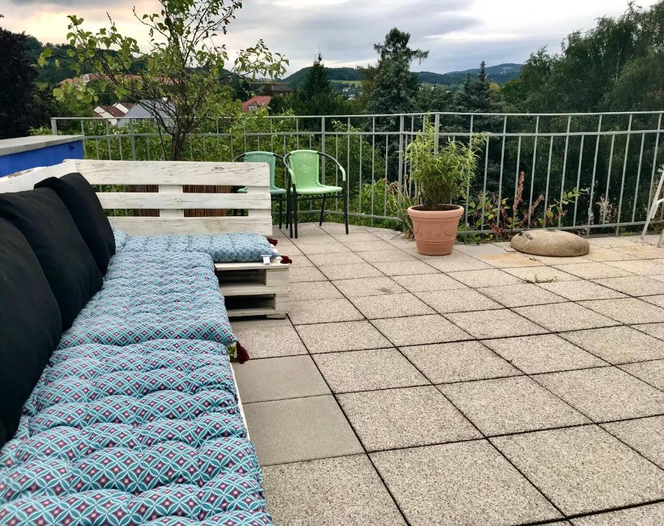 un sofá sentado en un patio junto a una valla en Stadtoase mit traumhaftem Ausblick, en Linz