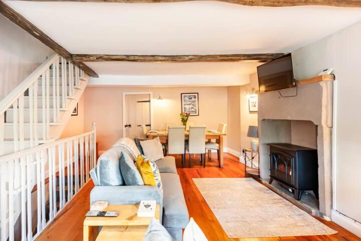 a living room with a couch and a fireplace at Duck Cottage - Cosy Cottage - Central Location in Haworth