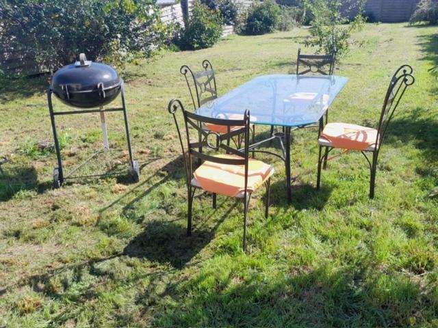 - une table et des chaises avec un barbecue dans l'établissement Au logis du circuit des 24h00, au Mans