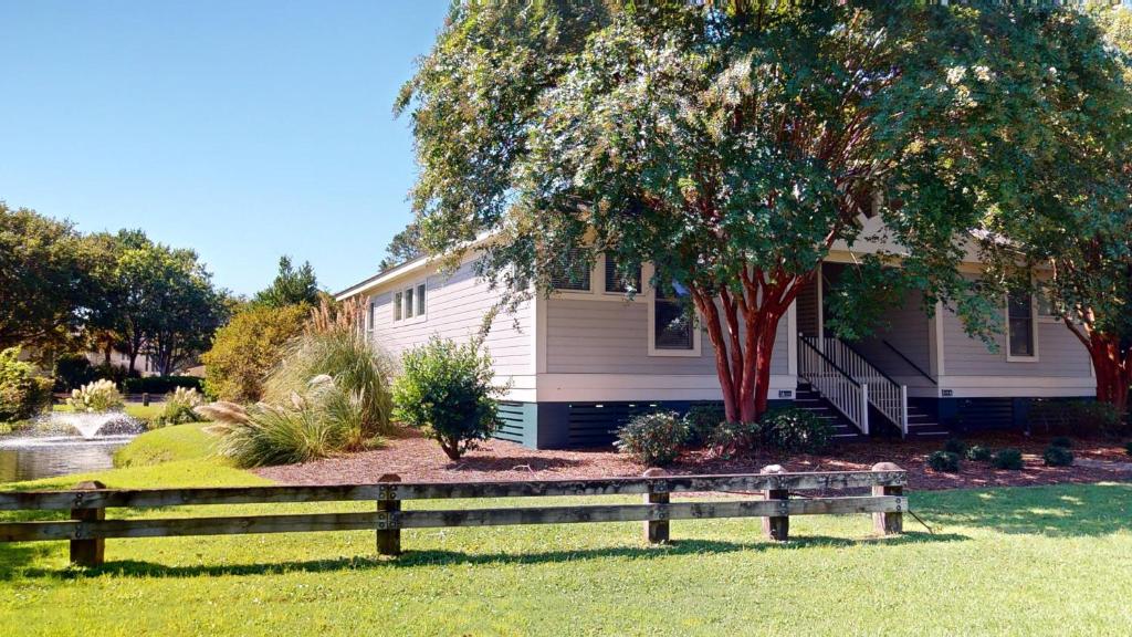 a house with a wooden fence in front of it at 2 Bdrm Lakeside Villa Scenic View With Amenities in Pawleys Island