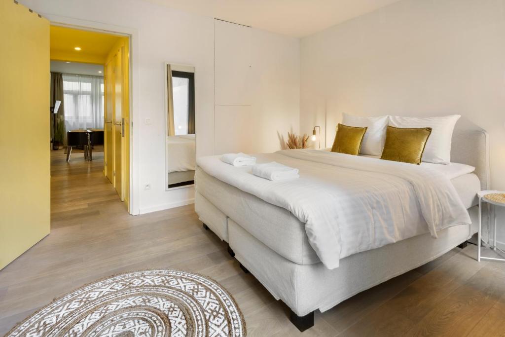 a bedroom with a large bed and a living room at R73 Apartments by Domani Hotels in Antwerp