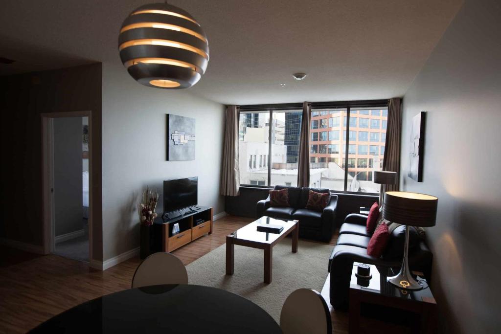 een woonkamer met een bank en een tv bij Obasa Suites @ The Hamilton in Regina