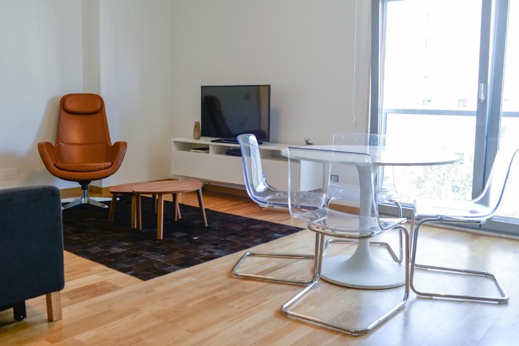 a living room with a table and chairs and a tv at Lisbon Brown Cozy Apartment in Lisbon