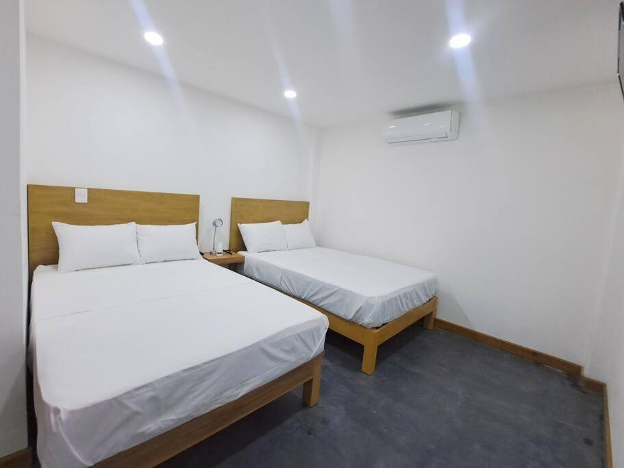 2 camas en una habitación pequeña con 2 camas individuales en lugar para descansar210, en Fortín de las Flores