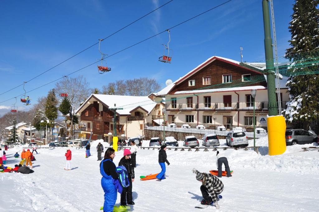 un grupo de personas en la nieve en una pista de esquí en Hotel Miramonti, en Gambarie dʼAspromonte