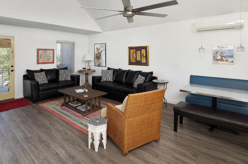 a living room with black furniture and a piano at Folly Vacation Perfect Purple Palace Apt C in Folly Beach
