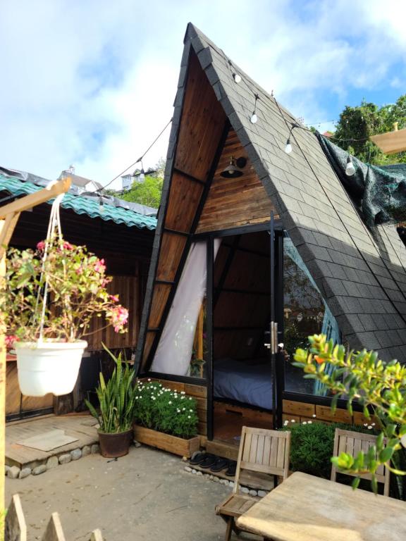 een klein huis met een schuin dak bij Cleverlearn's Homestay & Coffee in Ấp Ða Lợi