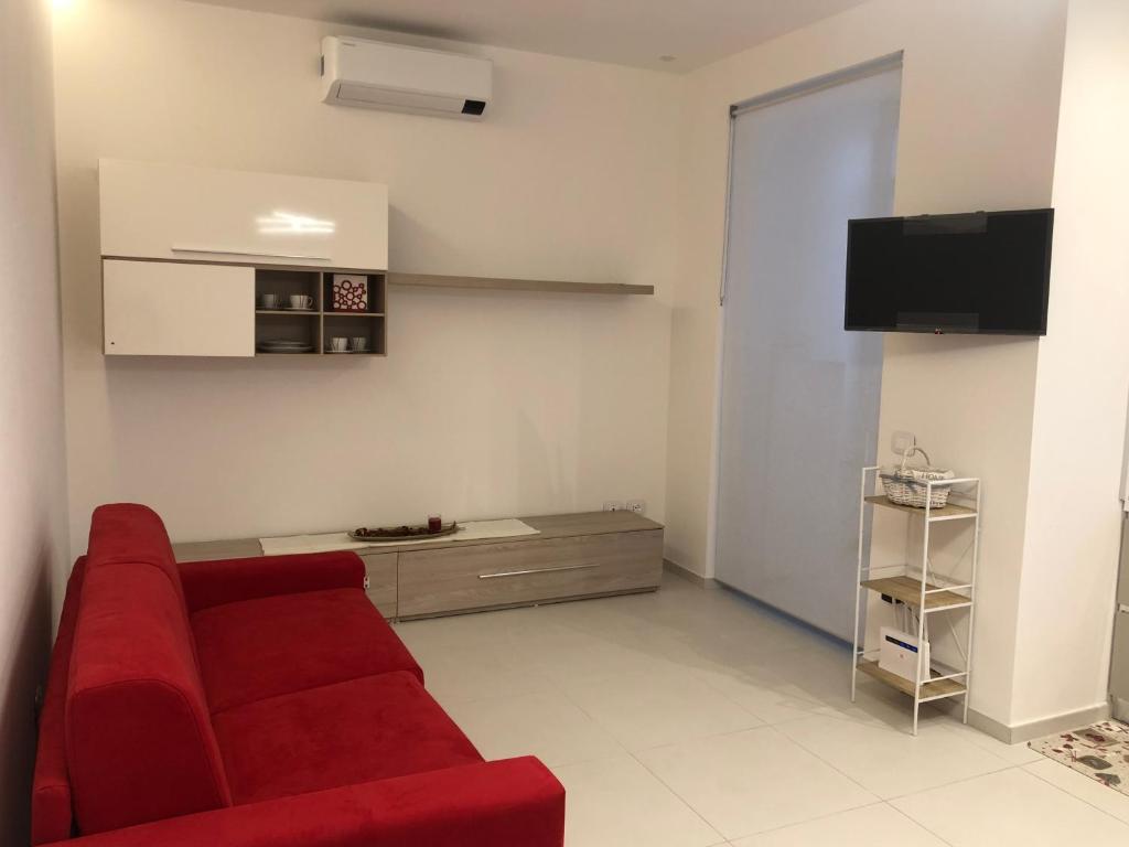 a living room with a red couch and a tv at Casa Vacanze Il Divano Rosso in Foligno