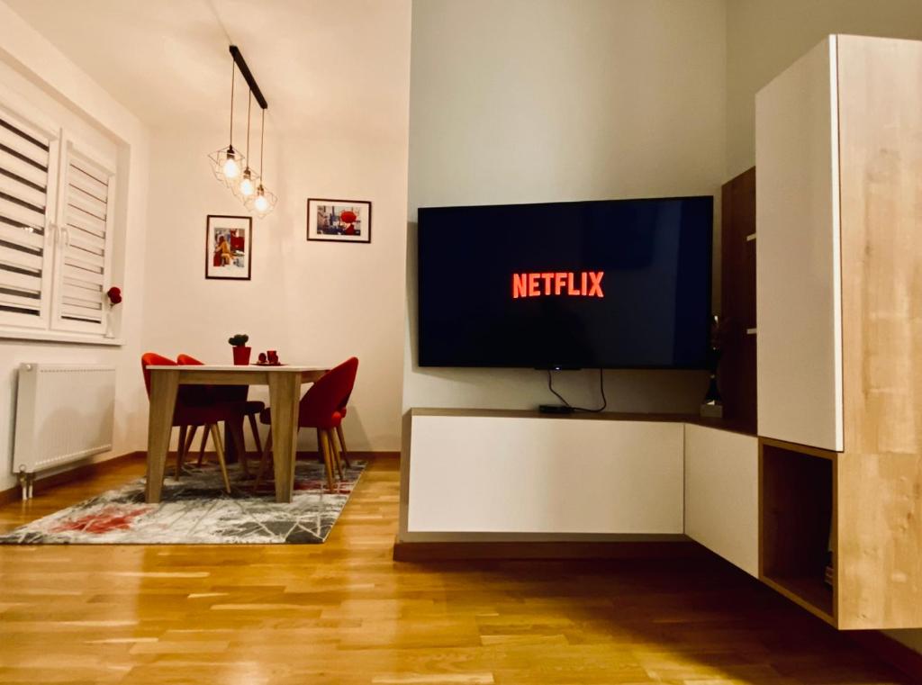 un soggiorno con tavolo e TV a parete di Apartman Pale Jahorina a Pale