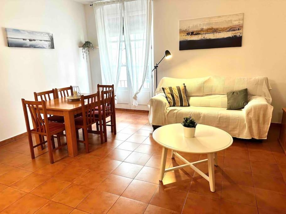 a living room with a couch and a table and chairs at Apartamento St Agustí - Centro in Mataró