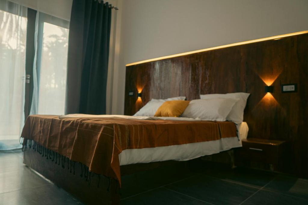 a bedroom with a large bed with a wooden headboard at Villa Taouzert in Tozeur