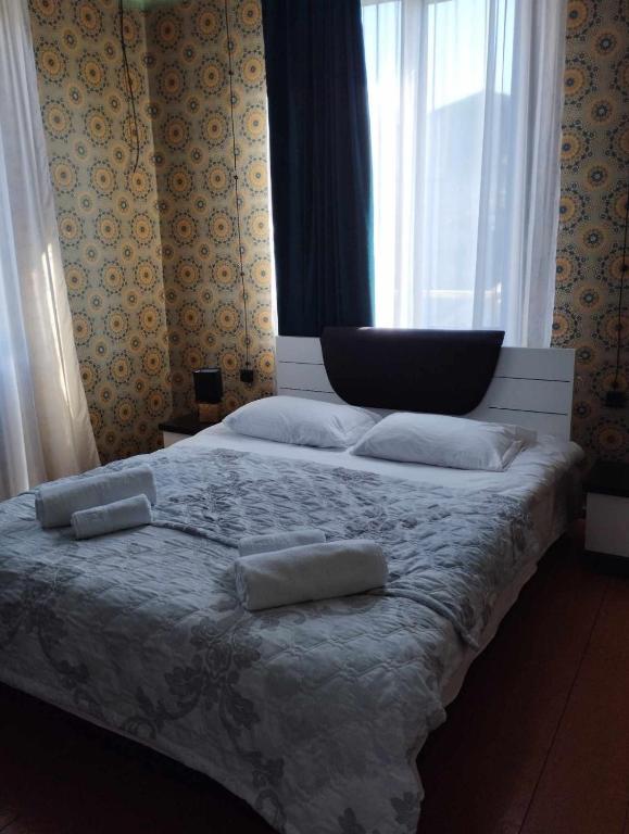 ein Schlafzimmer mit einem Bett mit zwei Kissen und einem Fenster in der Unterkunft GuestHouse Oni-Li in Oni