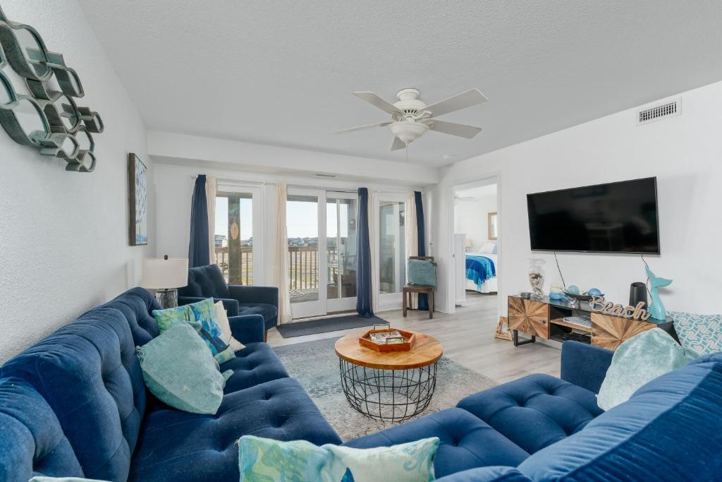 a living room with blue couches and a tv at 7080 - Atlantic Paradise by Resort Realty in Rodanthe