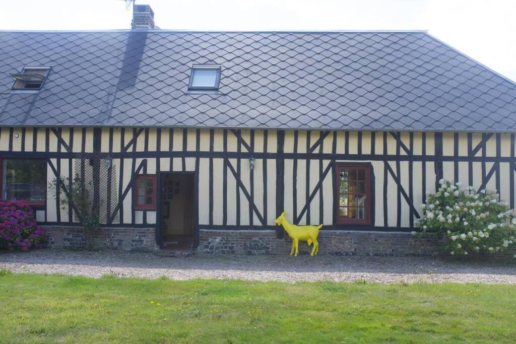 una casa con un animal amarillo delante de ella en Maison entière avec piscine chauffée 4p, en Brétigny