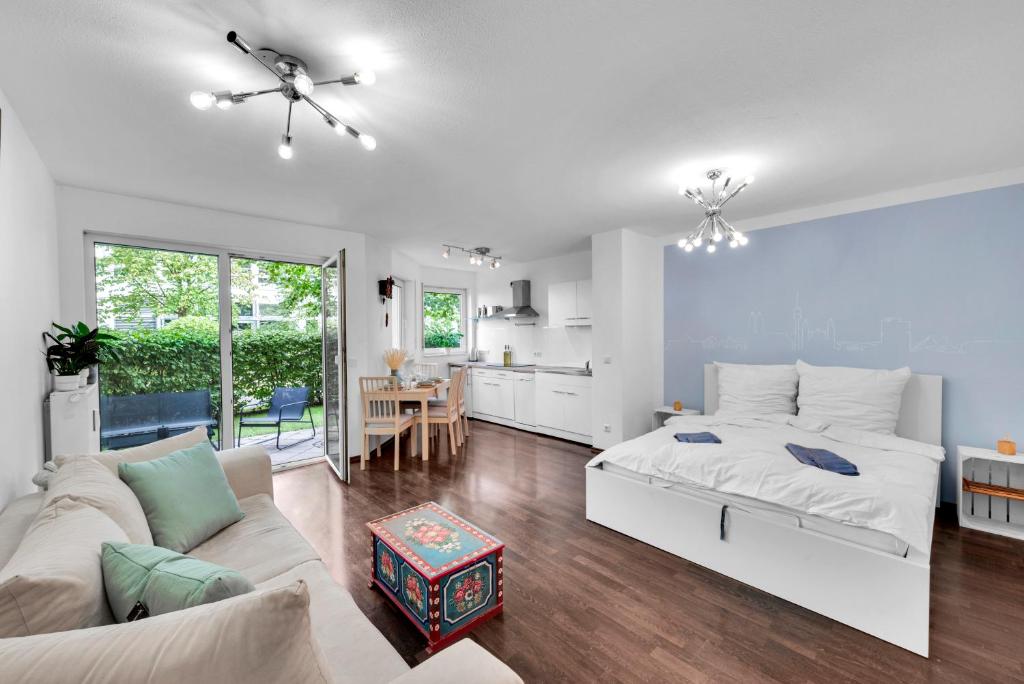 a white bedroom with a bed and a living room at Wohnung im Herzen Münchens nähe Hauptbahnhof in Munich