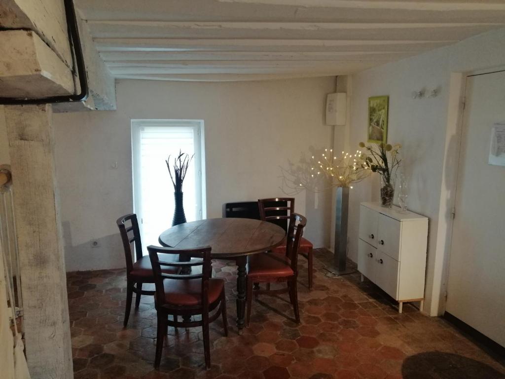 une salle à manger avec une table et des chaises dans l'établissement gitesevin F3B, à Saint-Forget