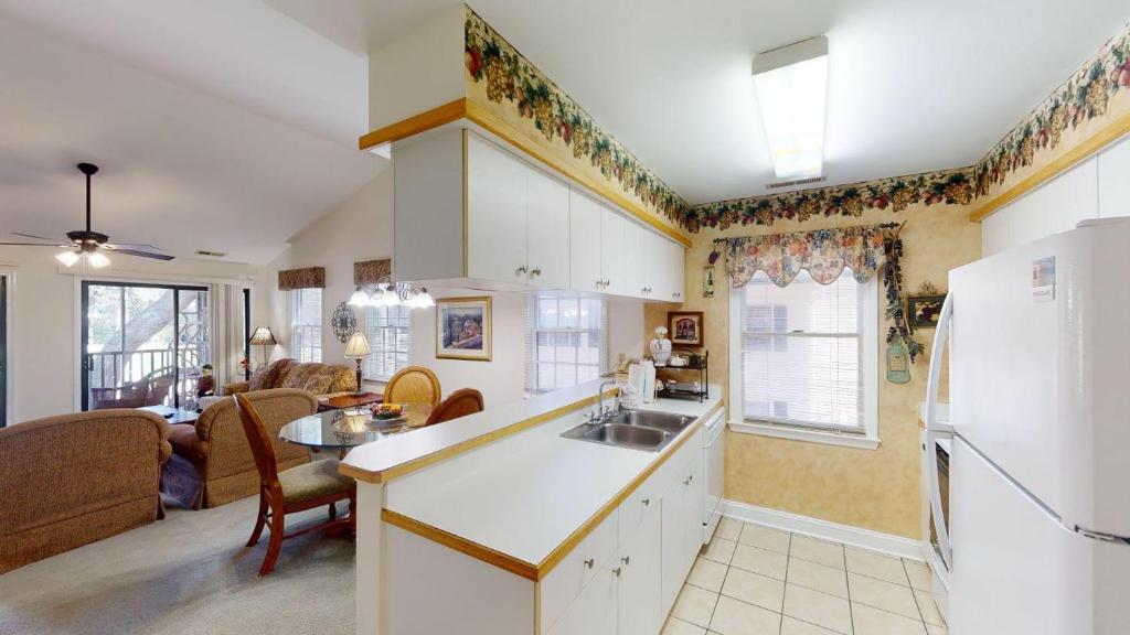 a kitchen and living room with a white refrigerator at Pawleys Plantation Greens 1 Bedroom Retreat in Pawleys Island