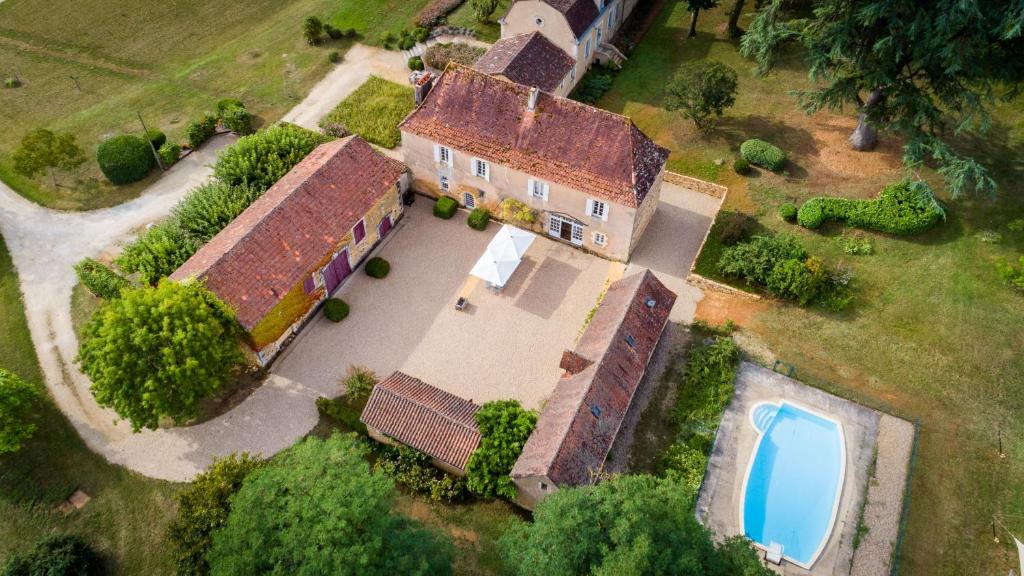 een luchtzicht op een oud huis met een zwembad bij le Domaine du Trouiller in Cendrieux