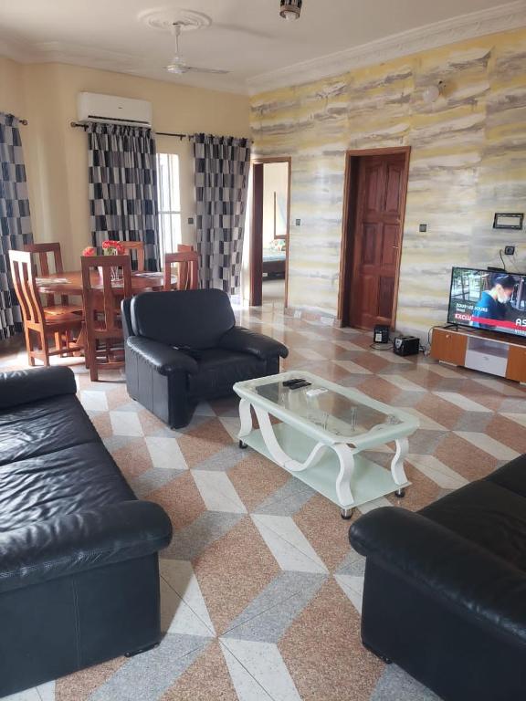 ein Wohnzimmer mit Sofas und einem Couchtisch in der Unterkunft Agimdeluxe in Abomey-Calavi