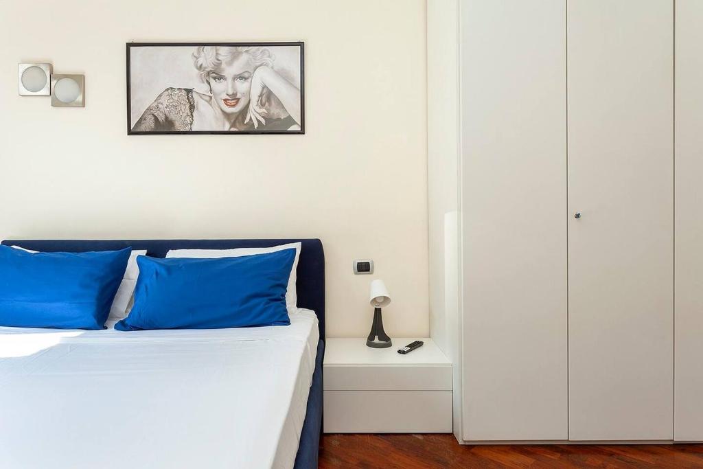 una camera da letto con letto e cuscini blu di Bellezza14 - Appartamento Porta Romana / Bocconi a Milano