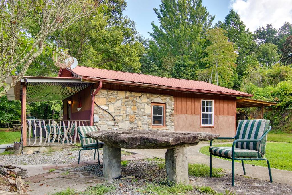 une table en pierre et deux chaises en face d'une cabine dans l'établissement Mountain-View Pisgah Forest Getaway with Fire Pit!, à Pisgah Forest