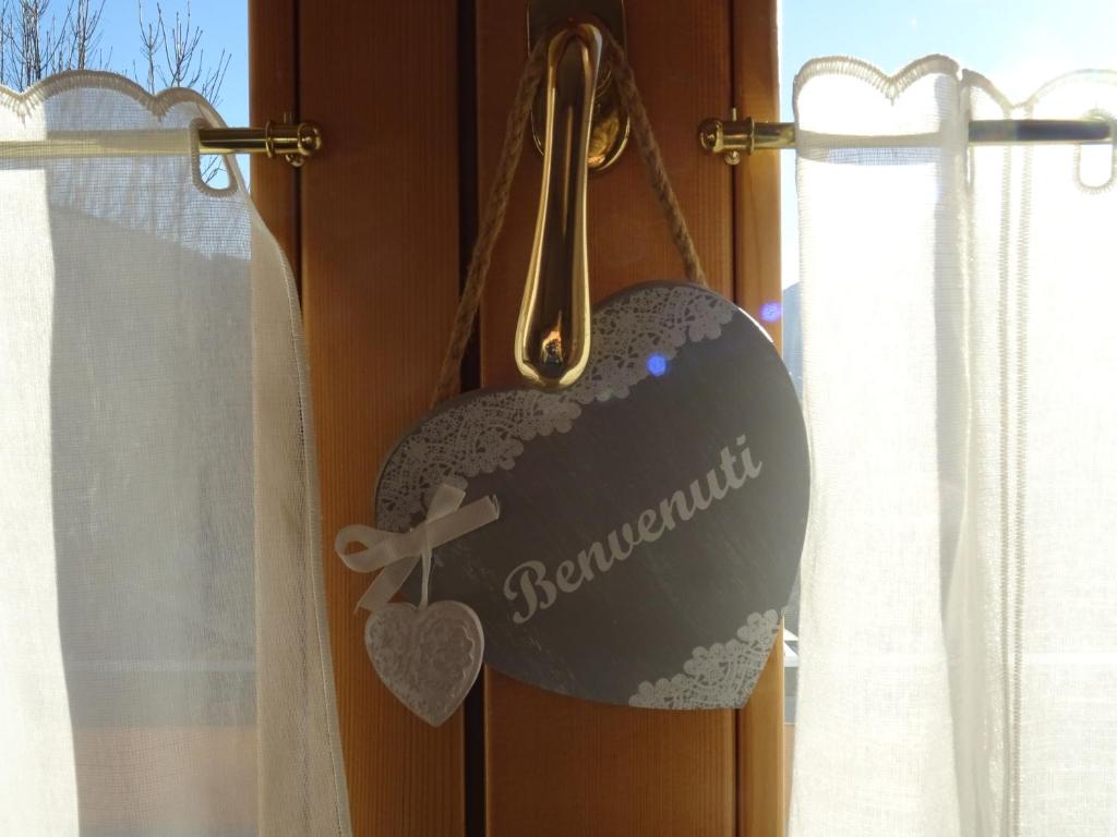 un cartello a forma di cuore appeso ad una porta di CASA VIDI a Madonna di Campiglio