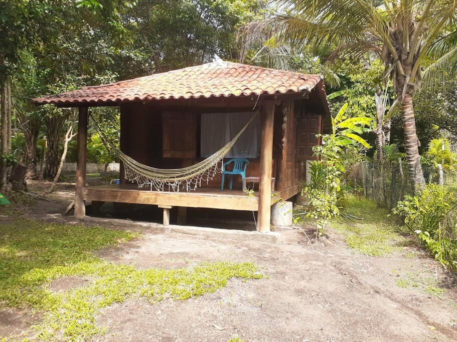 a hammock in a hut with a hammock at Chalé com privacidade em Imbassai in Mata de Sao Joao