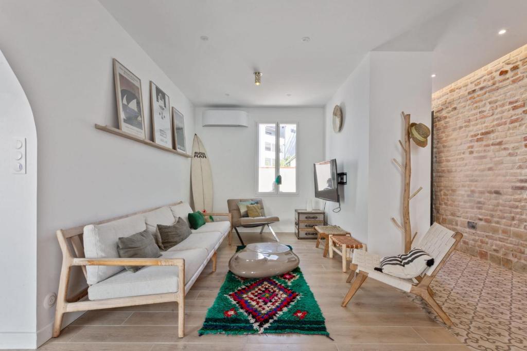 uma sala de estar com um sofá e uma parede de tijolos em Charming townhouse with air conditioning in Anglet - Welkeys em Anglet