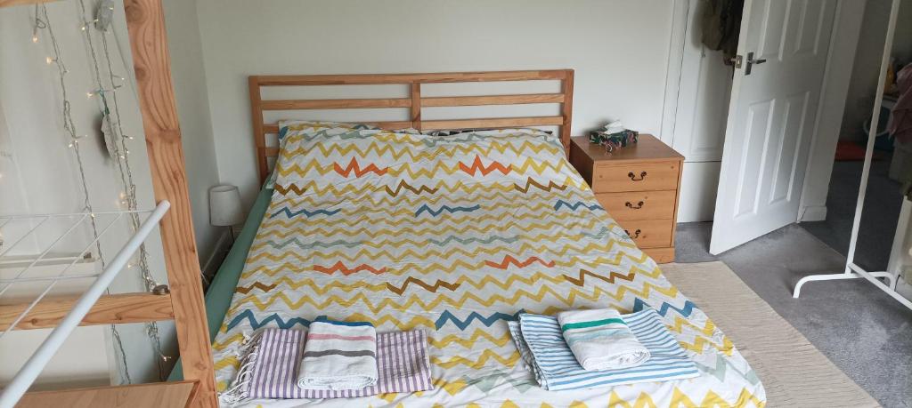 a bed with a colorful blanket on top of it at Rockrose Stay in Cardiff