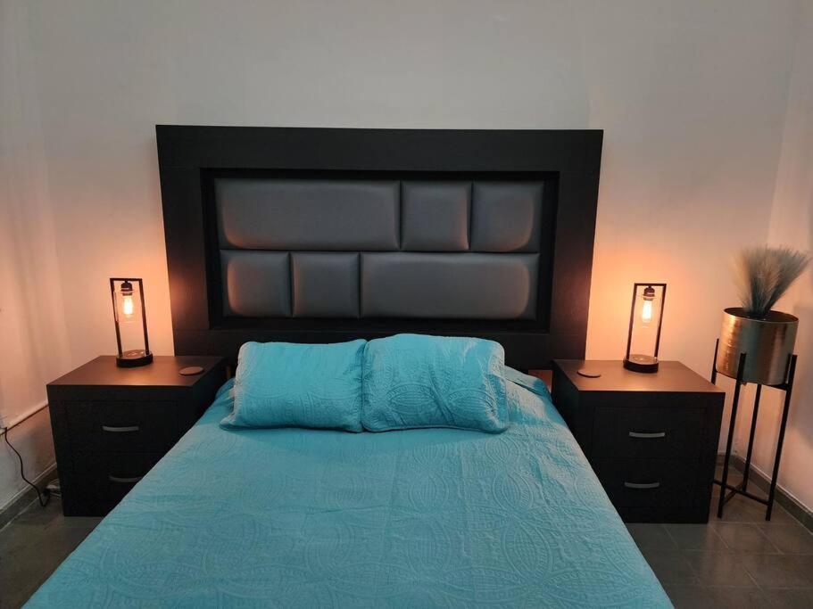 - une chambre avec un lit, 2 tables de chevet et 2 lampes dans l'établissement Bonito Departamento en Americana, à Guadalajara