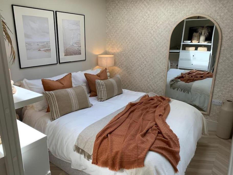 sypialnia z dużym łóżkiem i dużym lustrem w obiekcie West Wittering Beach Getaway w mieście West Wittering