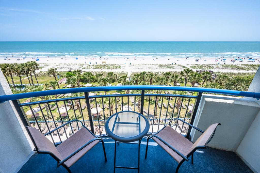 a balcony with chairs and a view of the beach at Stunning View, Direct Oceanfront, Boardwalk, Pools in Myrtle Beach