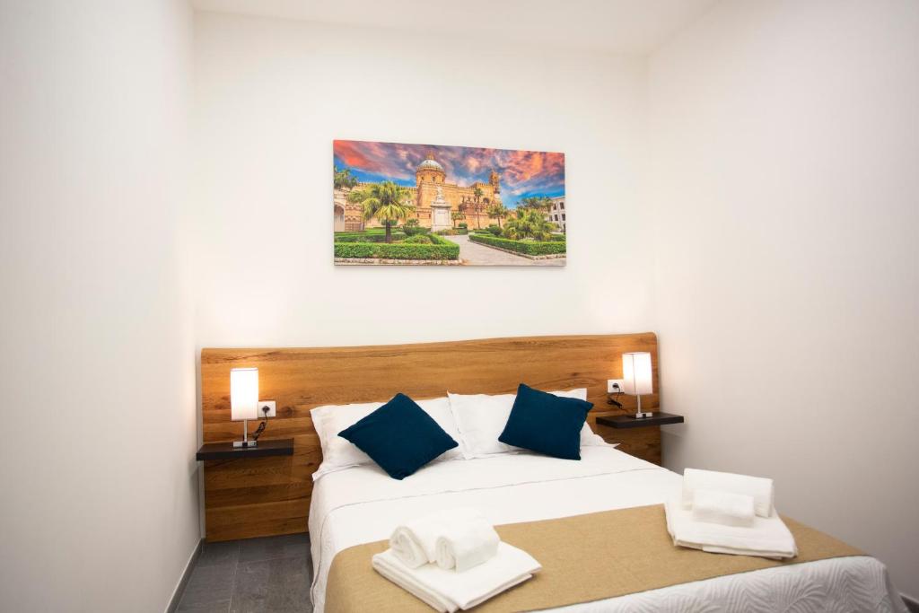 1 dormitorio con 1 cama grande con almohadas azules en Dimora Les Folies, en Palermo