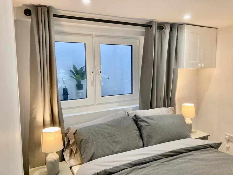 a bedroom with a bed and two windows at Brighton Palms 2 in Brighton & Hove