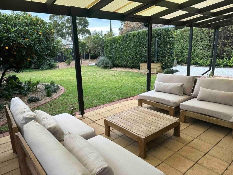 a patio with two couches and a coffee table at The Goody House in Unley