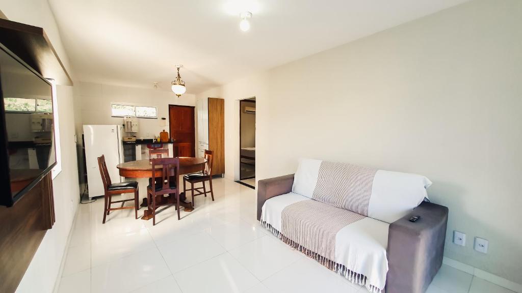 uma sala de estar com um sofá e uma mesa em CASA NA RUA DO PIRUÍ EM AREMBEPE com ar em Arembepe