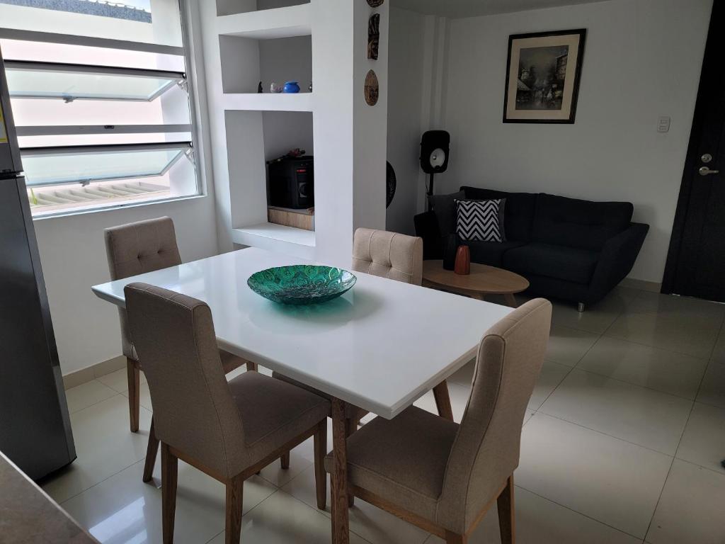a white dining room table with chairs and a bowl on it at Espectacular y amplio apartamento amoblado in Barranquilla