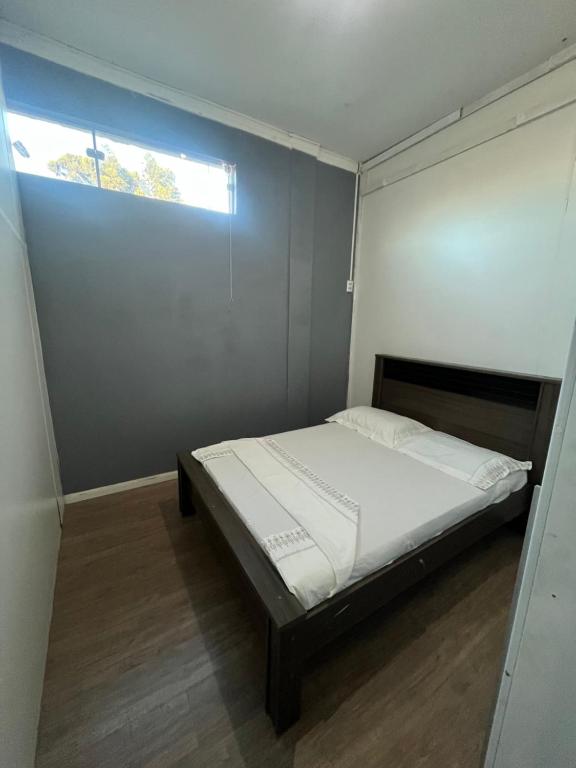 a small bedroom with a bed and a window at Quarto Hostel Curitiba in Curitiba