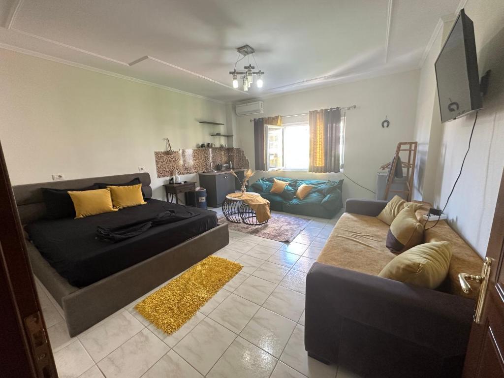 a living room with a bed and a couch at Koa Studio Apartment in Korçë