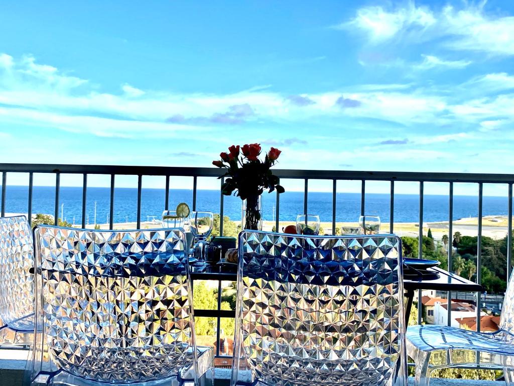 d'une table avec des chaises et un vase de fleurs sur le balcon. dans l'établissement Panoramic Sea view - Balcony - Tramway - 2 Bedrooms - Wifi - Fully equipped kitchen, à Nice
