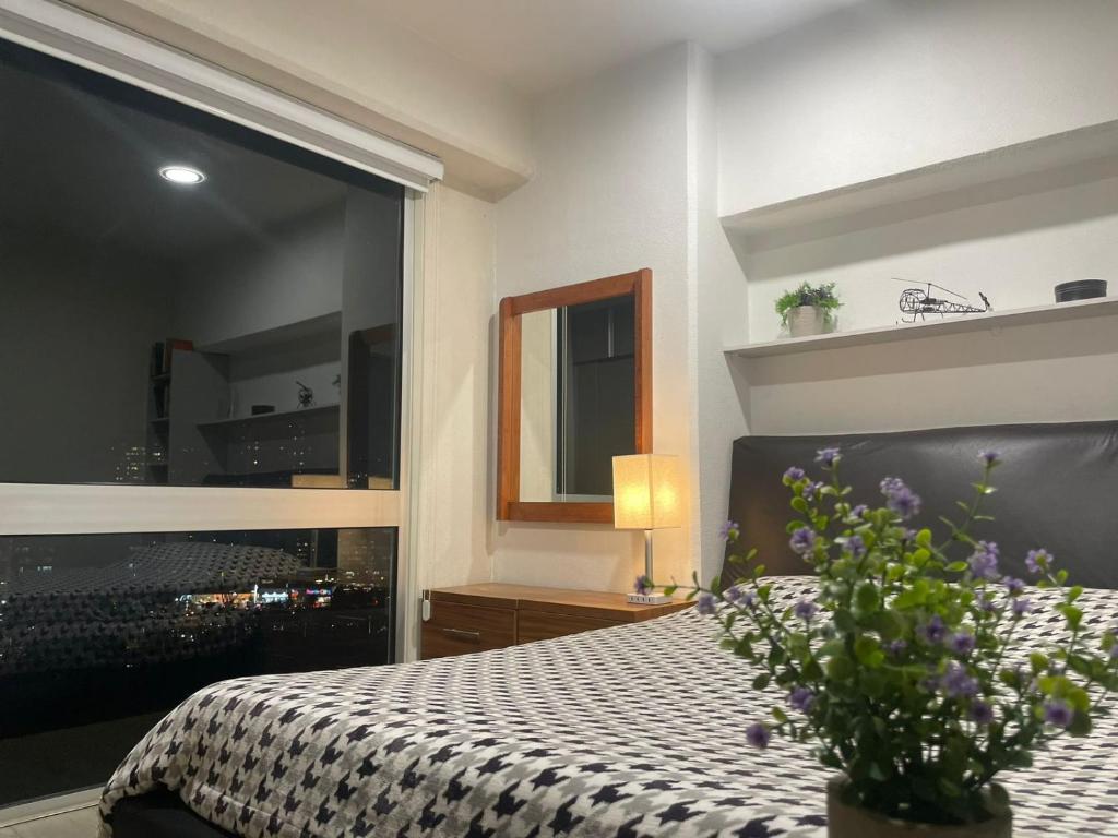 1 dormitorio con 1 cama con edredón blanco y negro en Hermoso departamento, wifi, gimnasio, parking., en Ciudad de México