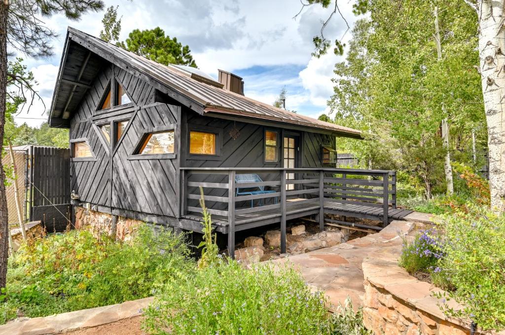 una casa negra con techo de gambrel en Pet Friendly Flagstaff Studio Cabin with Patio, en Flagstaff