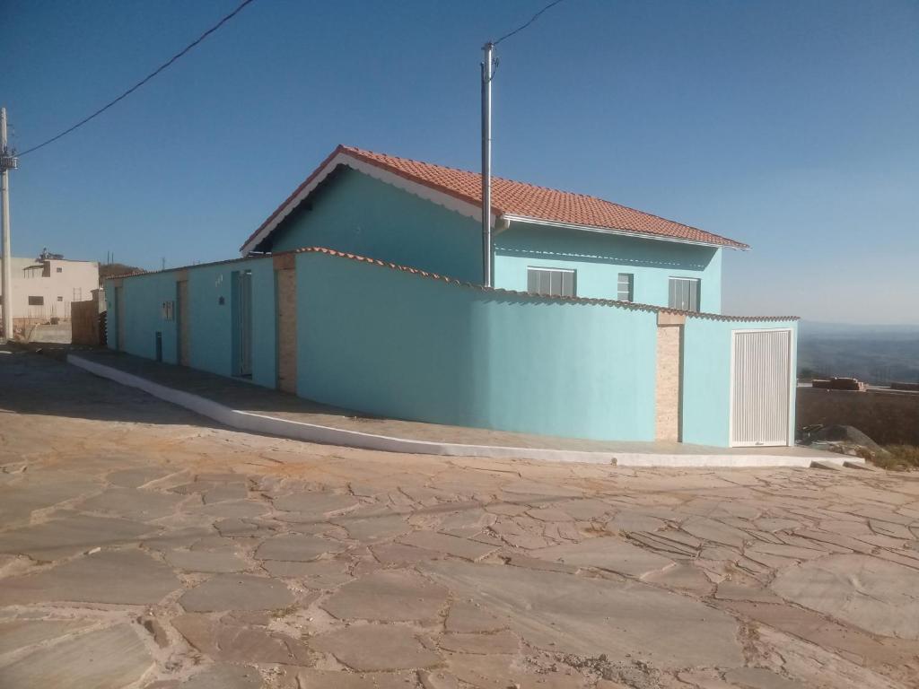 a blue house with a white fence in front of it at Casa Beija Flor in São Thomé das Letras