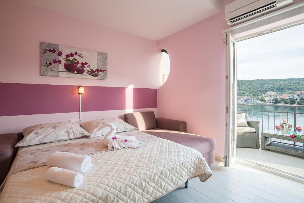 ein Schlafzimmer mit einem Bett mit einer lila Wand in der Unterkunft Apartments Pera in Marina