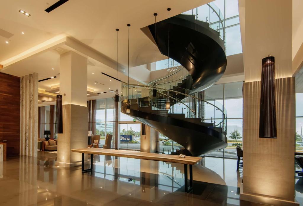 een wenteltrap in een lobby met een bank bij Hilton Garden Inn Puebla Angelopolis in Puebla