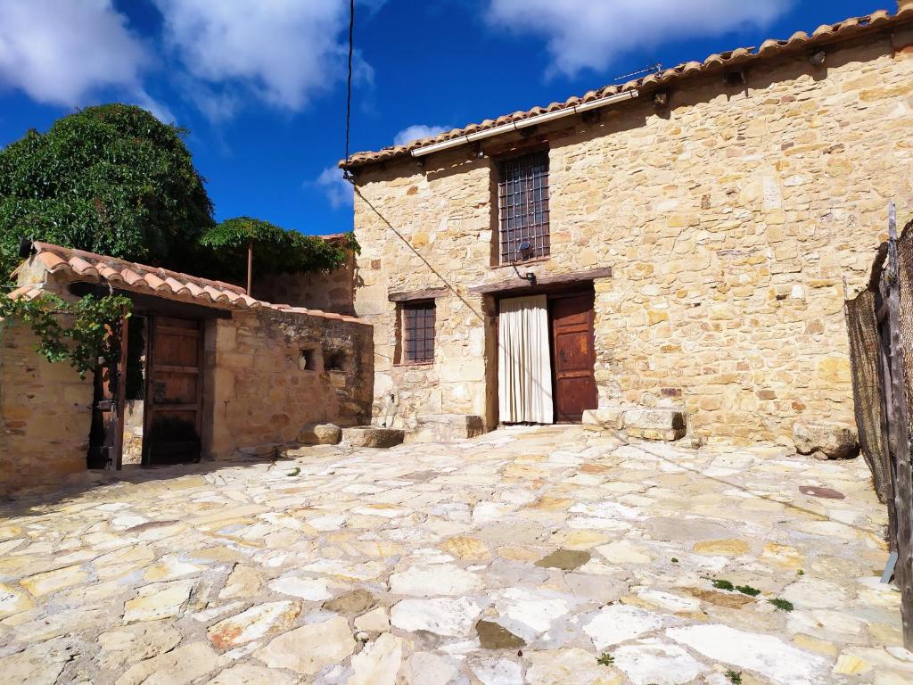 una antigua casa de piedra con una entrada de piedra delante de ella en Mas de Muñoz, en Mora de Rubielos