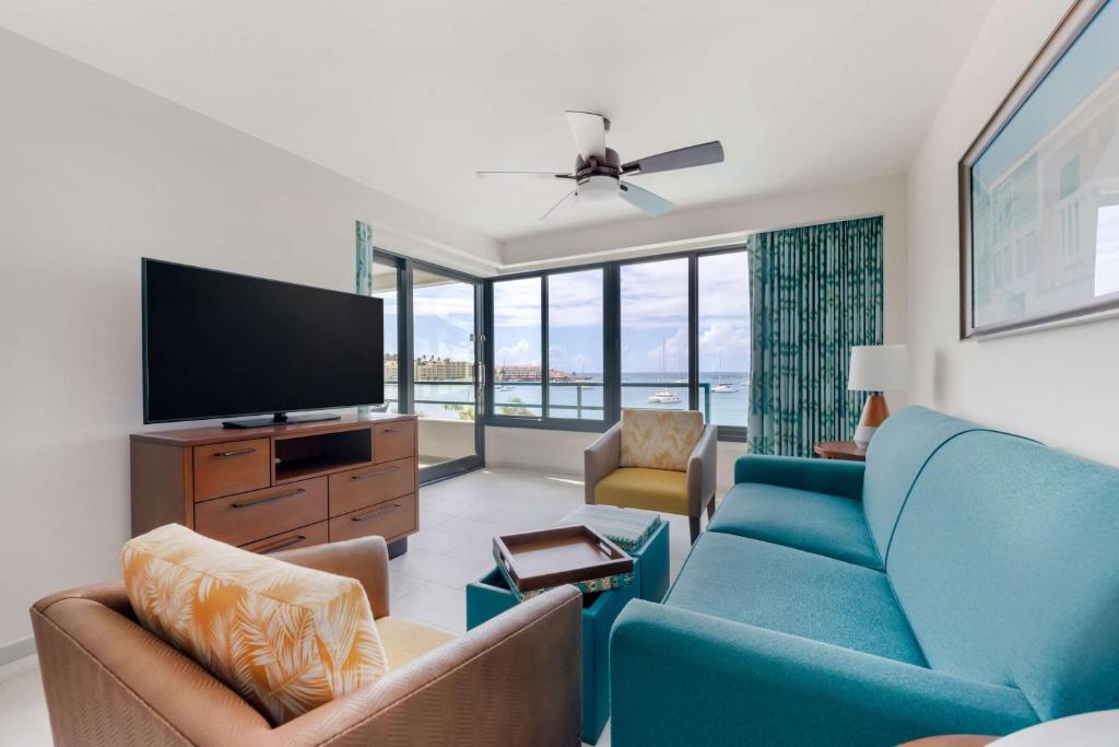 a living room with a blue couch and a flat screen tv at Hilton Vacation Club Royal Palm St Maarten in Simpson Bay