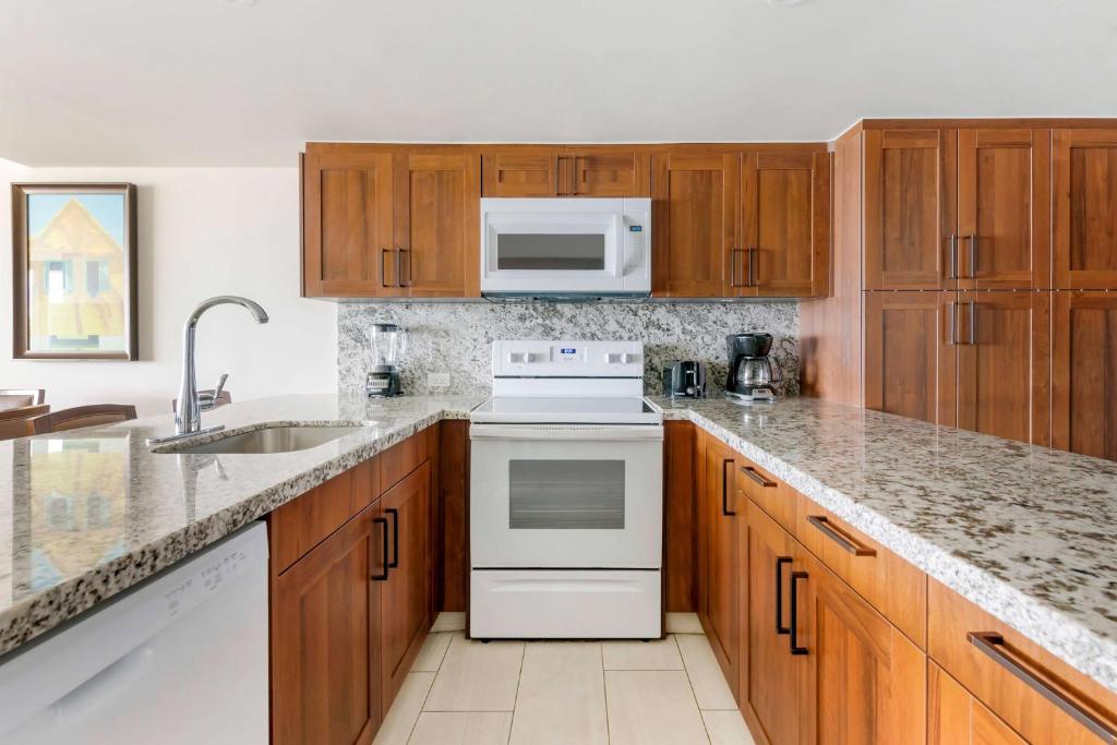 a kitchen with white appliances and wooden cabinets at Hilton Vacation Club Royal Palm St Maarten in Simpson Bay