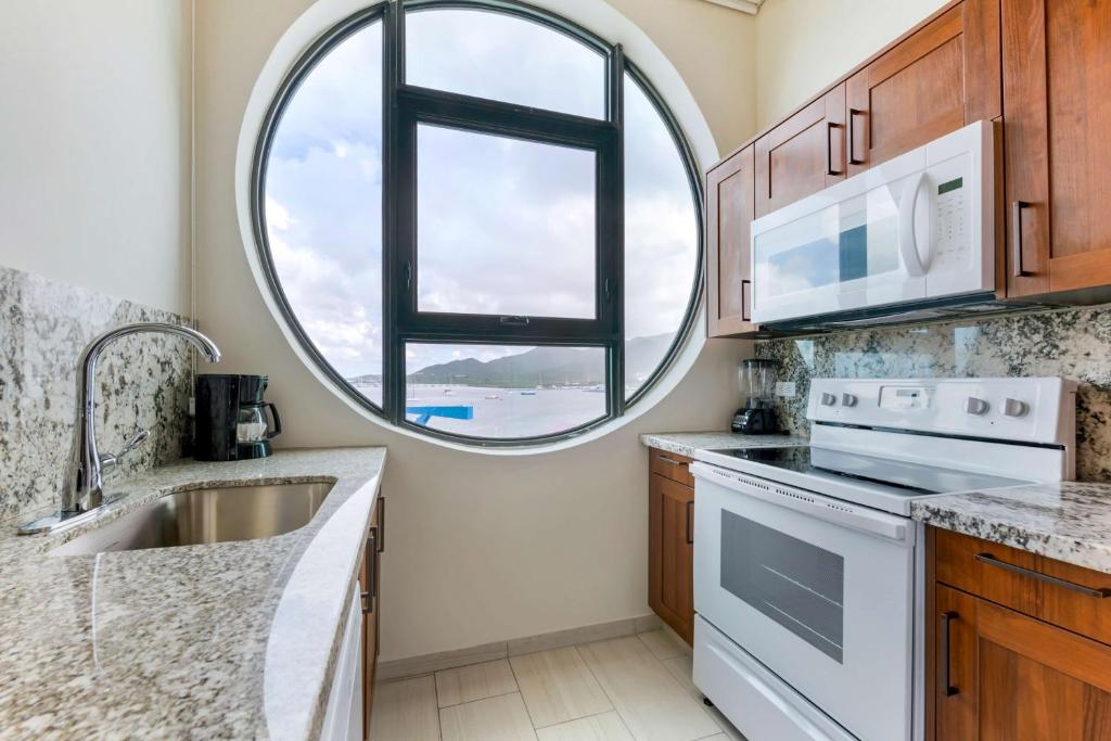 a kitchen with a sink and a round window at Hilton Vacation Club Royal Palm St Maarten in Simpson Bay