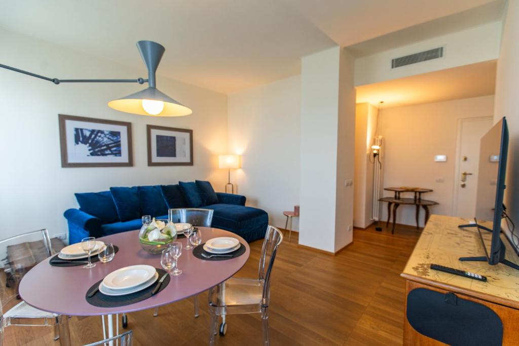 SkyAttic - 801 - CItyLife - 1 min Domodossola M5 في ميلانو: غرفة معيشة مع طاولة وأريكة زرقاء